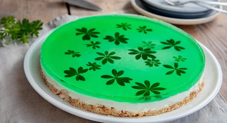 Grüne Philadelphia Torte mit Waldmeister-Gelee und zarten Blüten. Ein erfrischender Genuss!