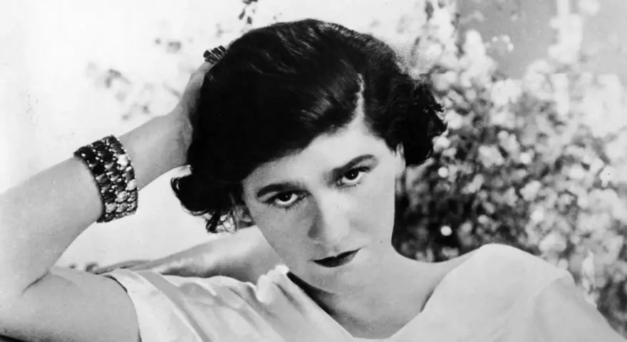 Coco Chanel negli anni '20, con un bracciale scintillante e un'espressione enigmatica.