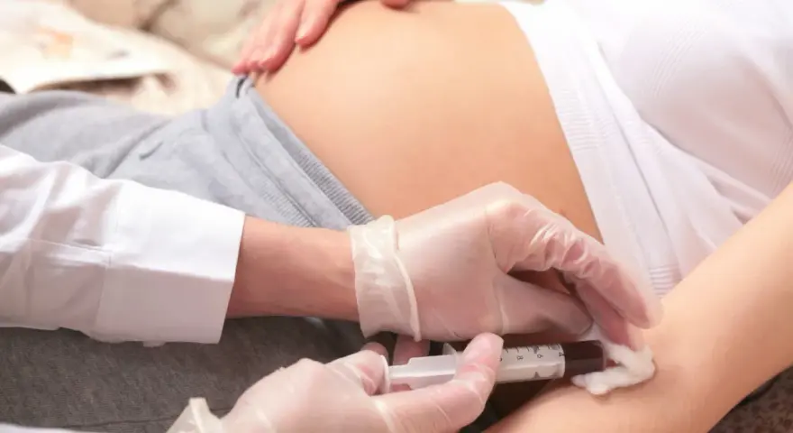 Pobieranie krwi od ciężarnej do badań, które mogą wykryć konflikt serologiczny i wady genetyczne u płodu.