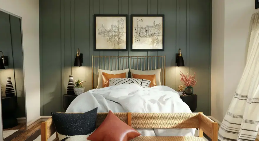 Elegantes dormitorios pequeños con encanto. Cama dorada con ropa blanca, dos cuadros de ciudades y lámparas negras.