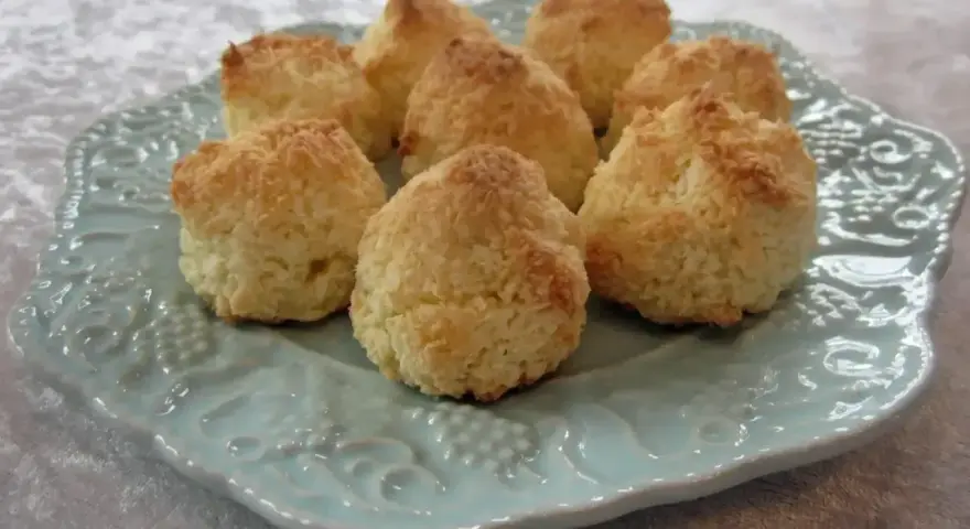Gyllene kokostoppar på en vacker ljusblå tallrik. Perfekt för ett enkelt kokostoppar recept.