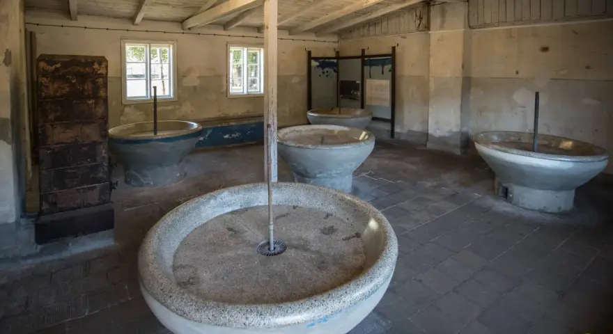 Wnętrze muzeum Stutthof z kamiennymi kadziami, które służyły do prania.