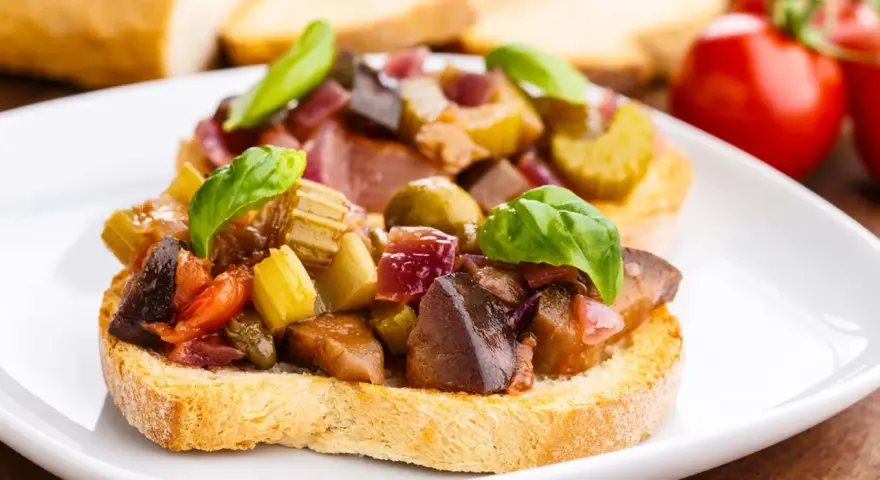 Bruschetta garnie d'un mélange coloré de légumes, évoquant les délices de Capoue.