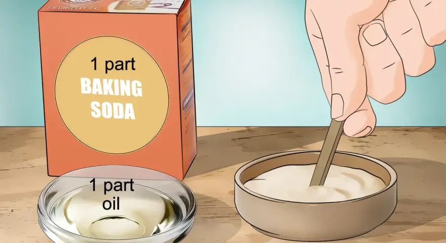 Learn how to remove acrylic glue using a paste of baking soda and oil. A hand mixes the paste in a bowl.