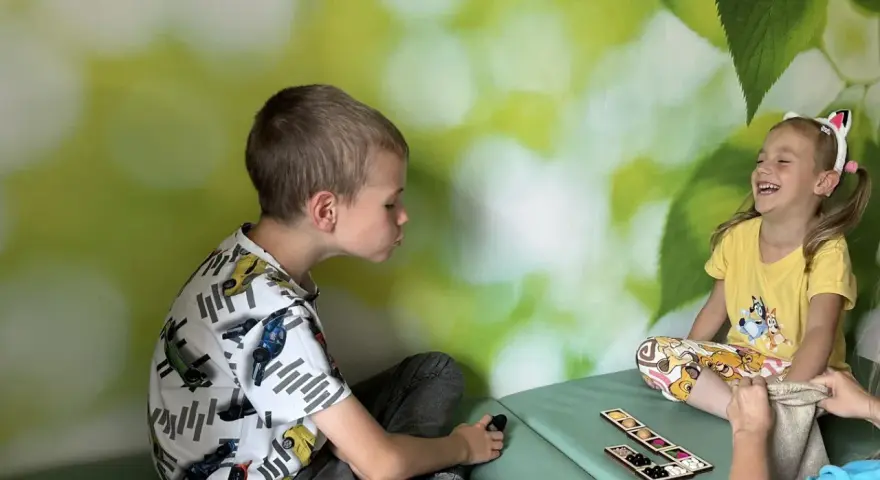 Chłopiec i dziewczynka, która ma 3 latek, bawią się grą sensoryczną.