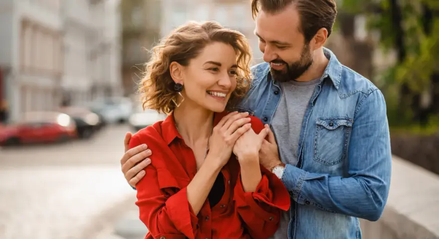 Uśmiechnięta para, on obejmuje ją ramieniem. Czy to oznaki flirtu w pracy, czy początek czegoś więcej?