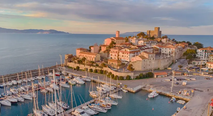 Porto con borgo medievale e castello, ideale per scoprire cosa visitare in Maremma in 3 giorni.