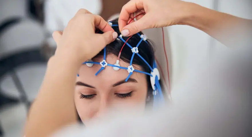 Eine Person erhält eine EEG-Untersuchung. Elektroden werden auf dem Kopf platziert, um die Gehirnaktivität zu messen.