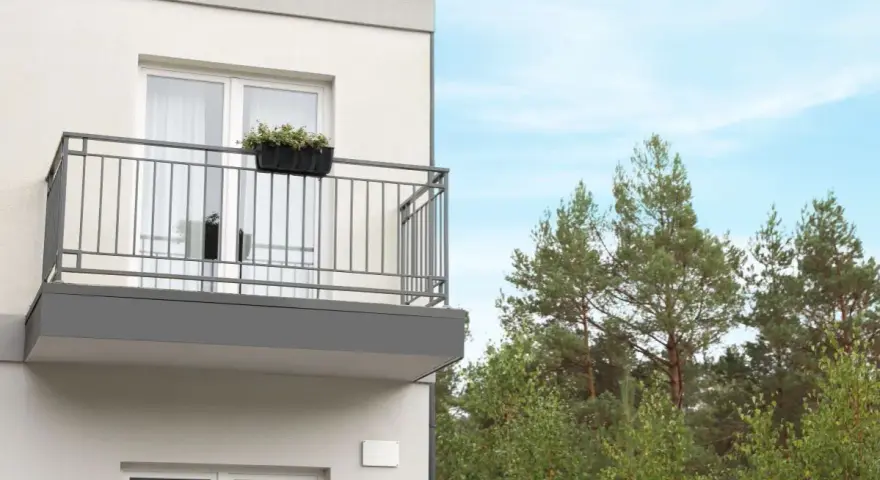 Nowy balkon z kwiatami, z którego roztacza się widok na las. Czy to miejsce wolne od podatku od balkonu?