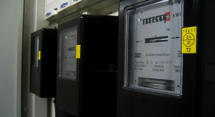 Trzy liczniki energii elektrycznej, jeden z nich pokazuje 3104577 kWh, czyli zużycie energii.