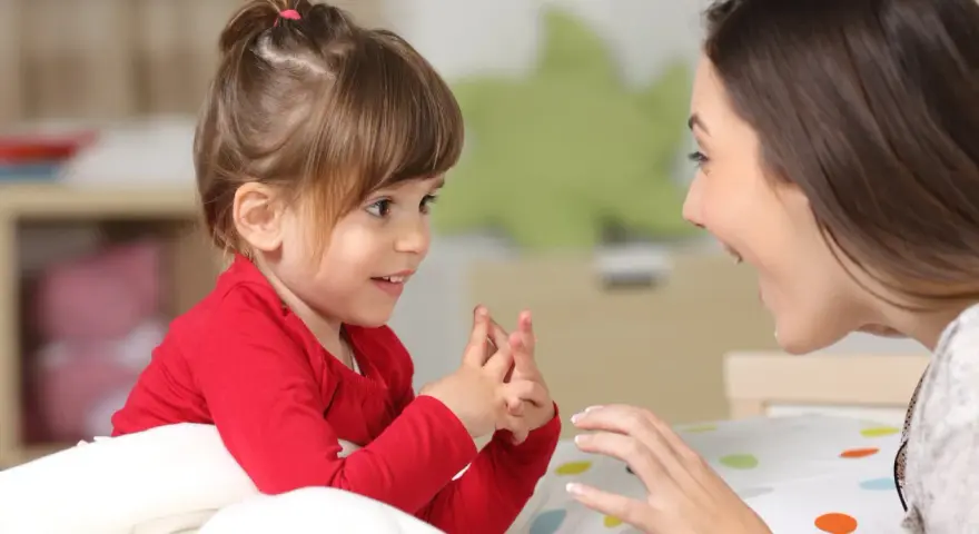 Ein kleines Mädchen und eine Frau sprechen liebevoll miteinander. Ein Moment der psychosexuellen Entwicklung, der Geborgenheit und Vertrauen schafft.