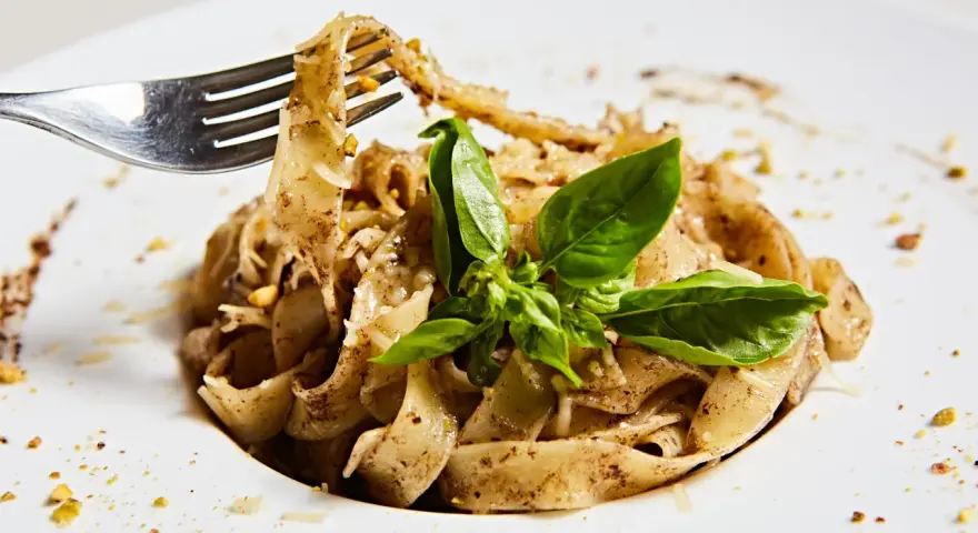 Wide tagliatelle z parmezanem i bazylią, kuszące aromatem, który zdradza, jaki smak ma trufla.