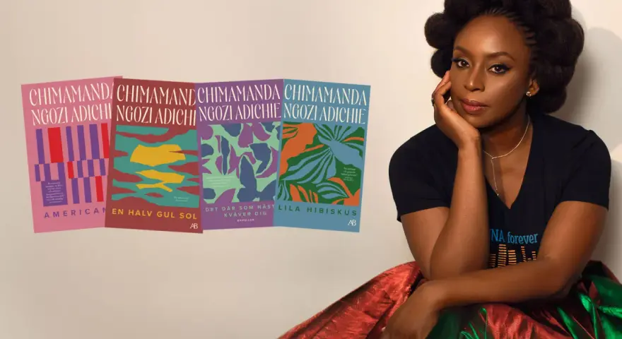 Chimamanda Ngozi Adichie sitter bredvid sina böcker, inklusive "Lila hibiskus".