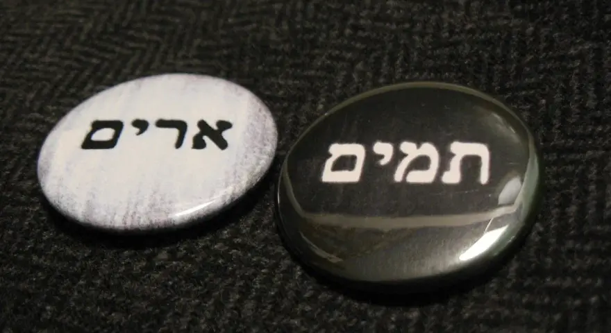 Two round pins with Hebrew text: "Urim" on a white background and "Thummim" on a black background.
