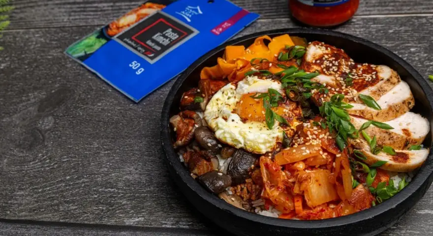 Pyszny Bibimbap przepis z kurczakiem, jajkiem sadzonym, grzybami, marchewką i kimchi. Idealny na szybki obiad.