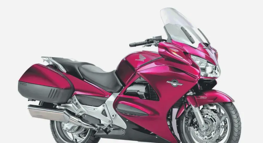 Różowy motocykl Honda ST 1300, gotowy na długie trasy, choć czasem zdarzają się mu drobne awarie.