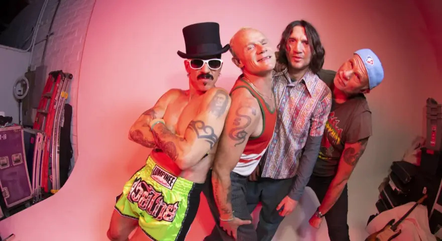 Les membres de Red Hot Chili Peppers posent ensemble, un groupe de rock iconique.