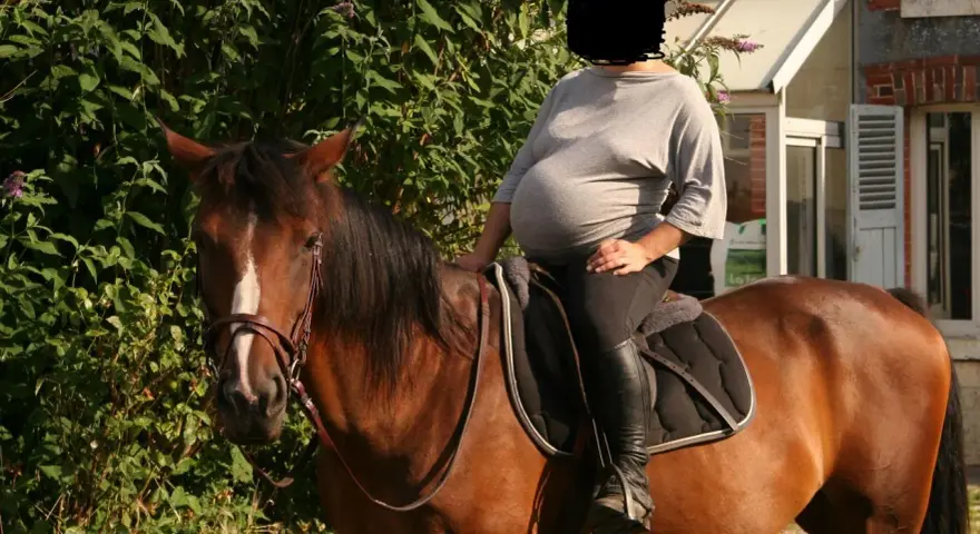 Une femme enceinte profite d'une balade à cheval, un moment de sérénité avant l'arrivée de bébé. L'équitation et grossesse, une combinaison harmonieuse.