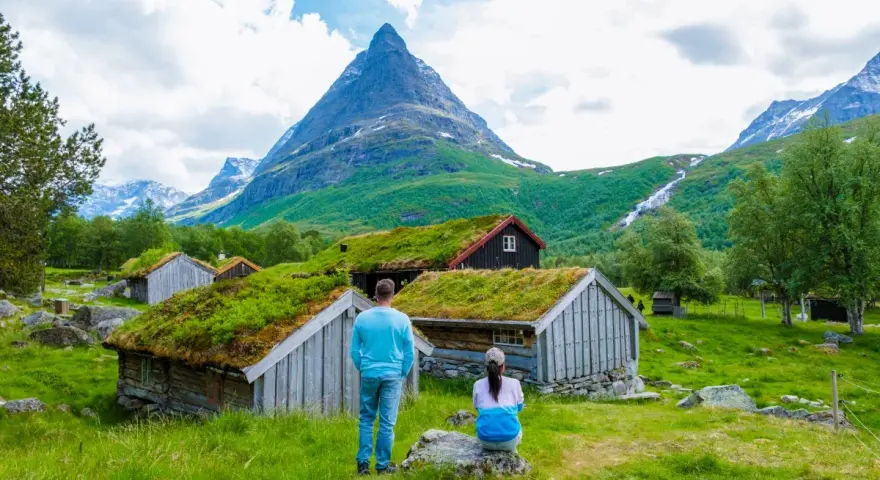 Para zwiedzająca norweskie chatki z zielonymi dachami. Czy do Norwegii można jechać na dowód osobisty? Tak, dowód wystarczy!