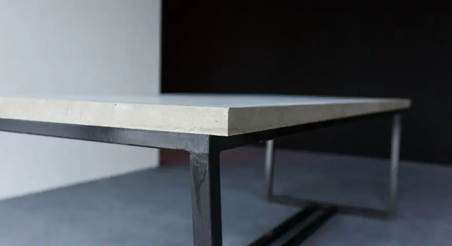 En stilren betongskiva på ett svart metallunderrede. Ytan är behandlad för att impregnera betongskivan och skydda den.