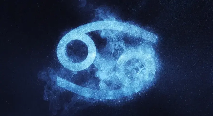 Błękitny symbol Raka, otoczony mgiełką i pyłem gwiezdnym, symbolizuje jego emocjonalne i opiekuńcze cechy charakteru.