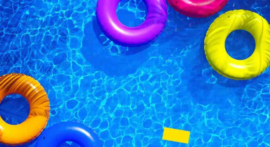 Colorful inflatable rings float in a sparkling blue pool, hinting at how to get crystal clear pool water.