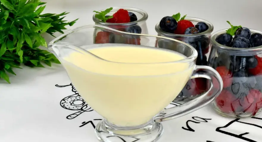 Krem custard i krem budyniowy w sosjerce, obok słoiczków z jagodami i malinami. Idealny deser na lato.