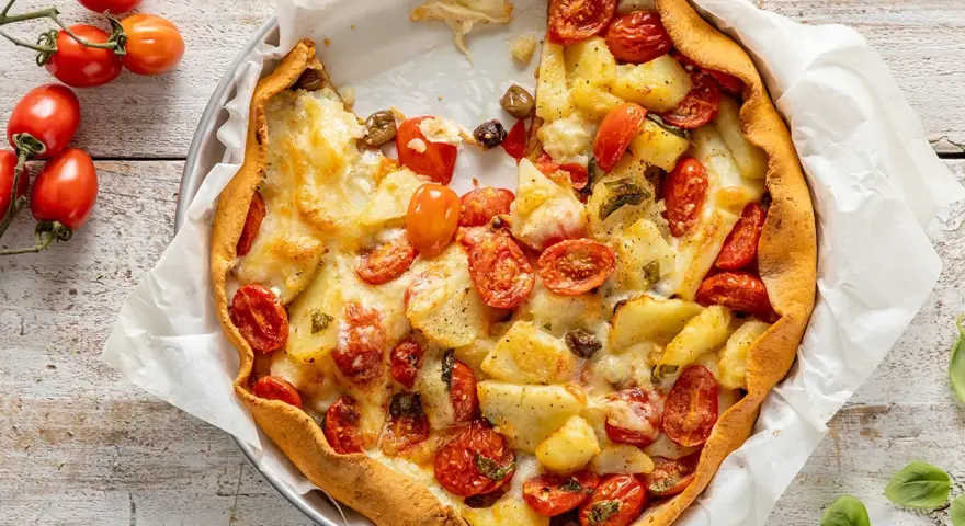 Torta salata estiva con patate, pomodorini e formaggio filante, un tripudio di sapori mediterranei.