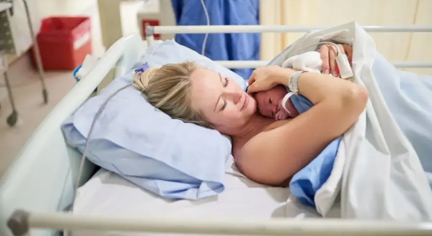 Szczęśliwa mama tuli noworodka. To początek jej urlop macierzyński, pełen miłości i czułości.