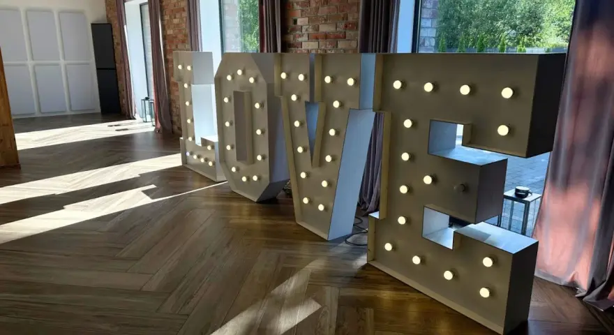 Podświetlane litery LOVE, idealne atrakcje na wesele, tworzą romantyczną atmosferę.
