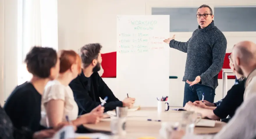 Man leder en workshop om möteskultur, där deltagarna fokuserar på kompetens utveckling.