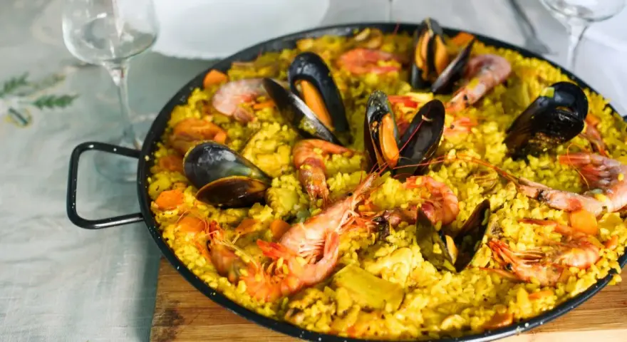 Pyszna paella z owocami morza, idealne hiszpania jedzenie. Krewetki i małże na żółtym ryżu.