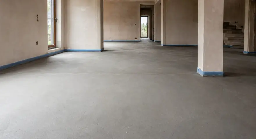 Nowy, betonowy strop czeka na wykończenie. Widać wyraźnie dylatację posadzki, która zapobiegnie pękaniu.