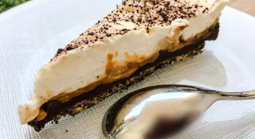 Pyszny kawałek banoffee pie z karmelem i bitą śmietaną, posypany czekoladą. Czy to lepszy wybór niż tarta cytrynowa?