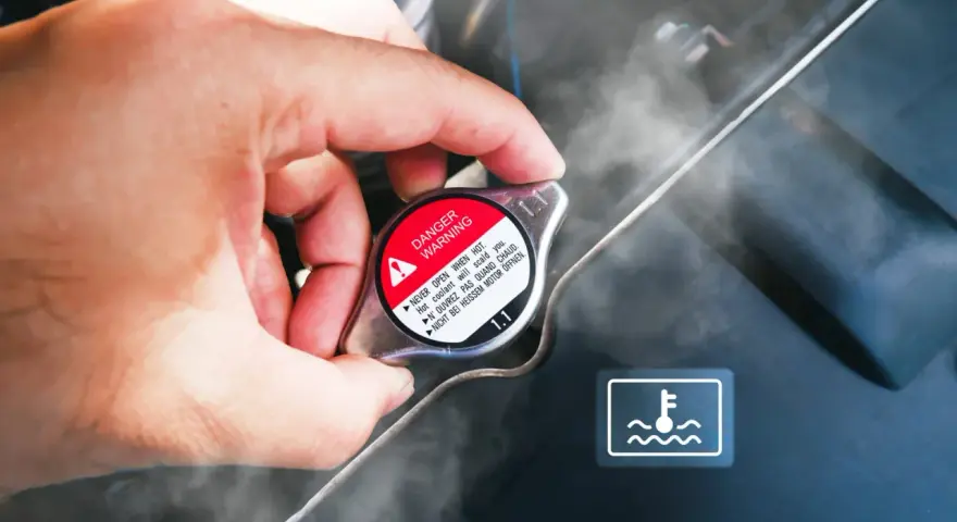 Dłoń dotyka gorącego korka chłodnicy, z którego unosi się para. Widoczny symbol ostrzegawczy i napis "DANGER WARNING". Kuhlmittel stand jest wysoki.