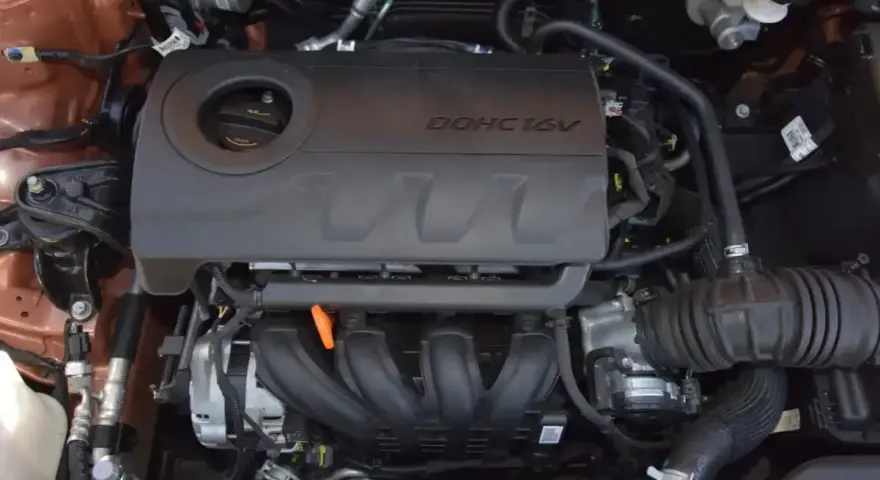 Silnik 1.4 MPI DOHC 16V w samochodzie. Widoczne elementy układu dolotowego i osłona silnika.