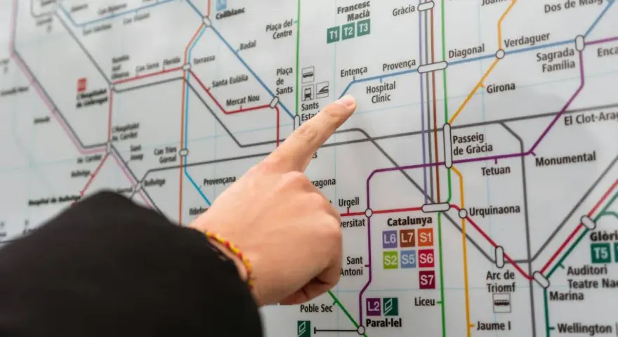 Palec wskazuje na mapę metra w Barcelonie, szukając trasy na lotnisko.
