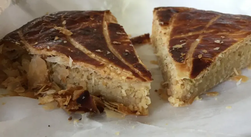 Deux parts de galette des rois coco, avec leur feuilletage doré et leur garniture généreuse, prêtes à être dégustées.