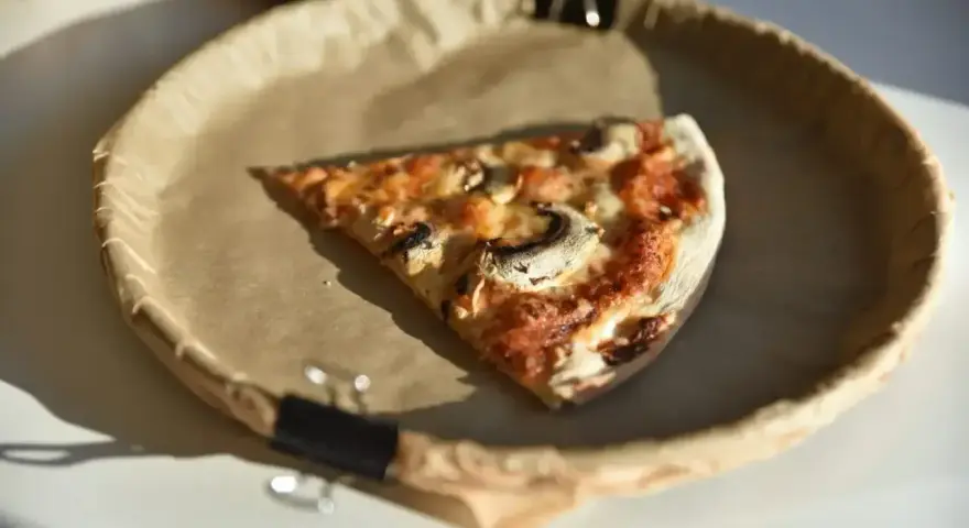 Kawałek pysznej pizzy capricciosa z pieczarkami i serem, idealna na szybki lunch.