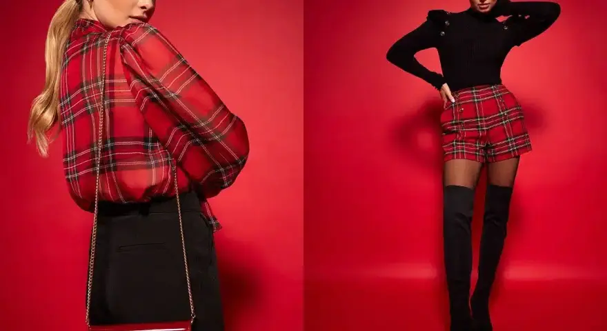 Modelka w czerwonym, kraciastym kiltcie i czarnym sweterku. Obok druga modelka w kraciastej bluzce i czarnych spodniach.