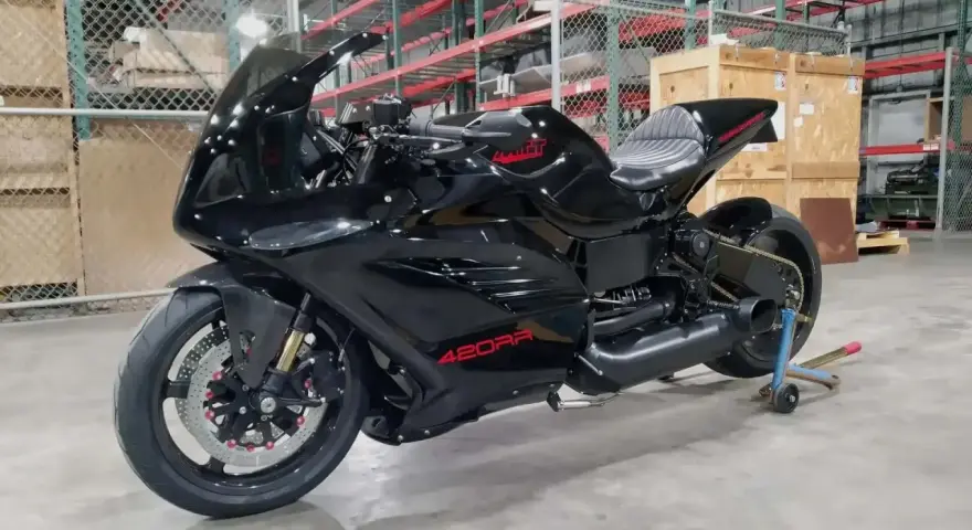 Moto nera lucida, la 420RR, con logo rosso sul serbatoio. Potrebbe essere la moto più veloce al mondo, pronta a sfrecciare.