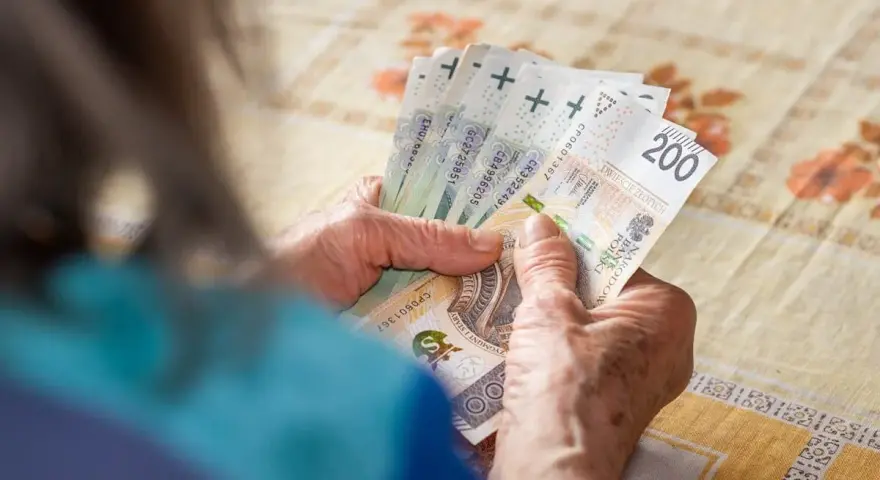 Dłonie liczą banknoty 200 zł. Zastanawiasz się, ile trzeba przepracować na 13 pensję?