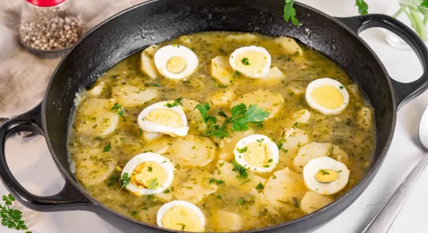 Patatas en salsa verde con huevos duros, un plato reconfortante y lleno de sabor, listo para disfrutar.