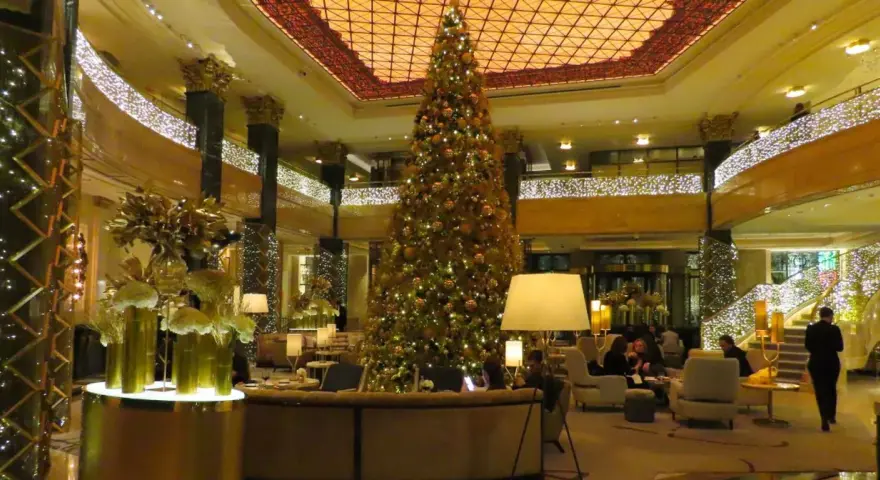 Elegancka wigilia w hotelu. Ogromna choinka i złote dekoracje tworzą świąteczną atmosferę.