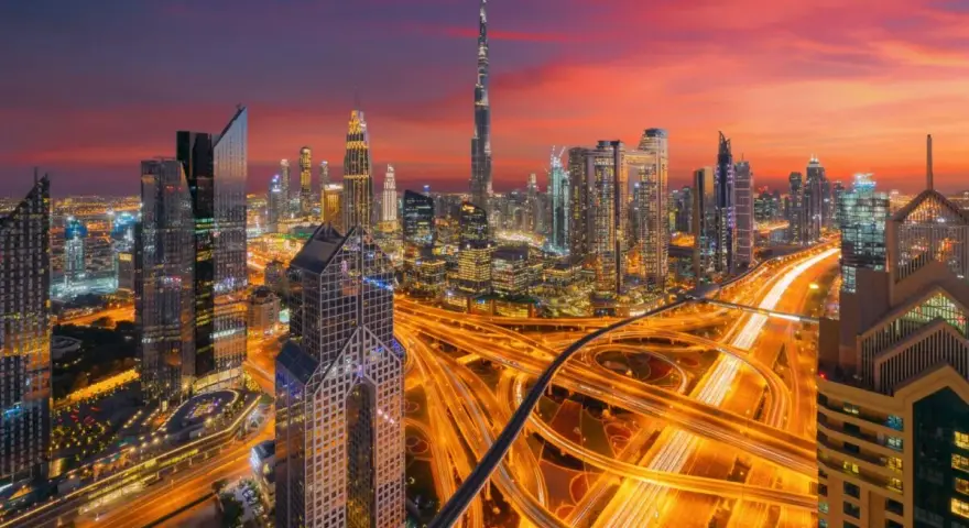 Wieczorny widok na Dubaj z drapaczami chmur i autostradą. W tle widać Burdż Chalifa. To miasto, gdzie kwitnie handel i **waluta Dubaju** jest symbolem rozwoju.