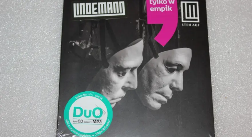 Okładka płyty Lindemann "Steh Auf" z dwoma maskami. "Tylko w Empiku" i "Duo" na zielonej naklejce.