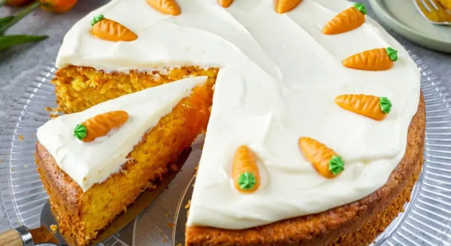 Saftiger karottenkuchen mit cremigem Frosting, dekoriert mit kleinen Marzipankarotten. Ein köstlicher Genuss!