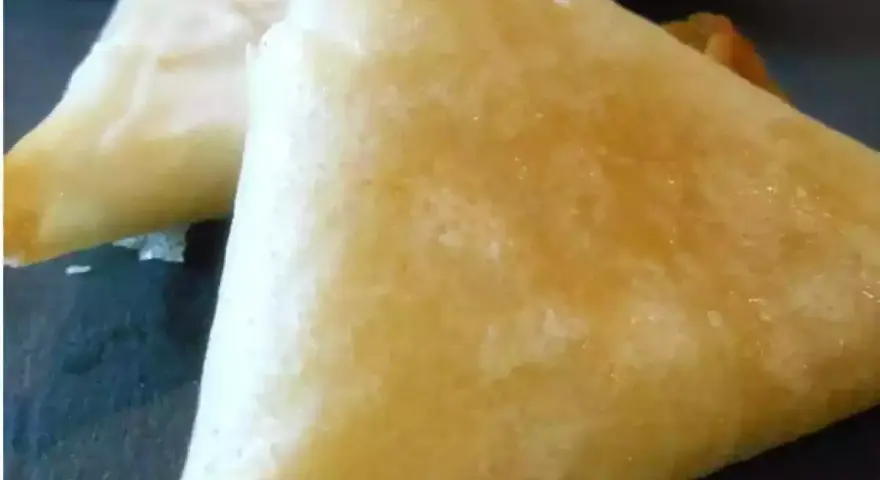 Deux samoussas dorés, un délice croustillant de brick chevre miel, prêts à être dégustés.
