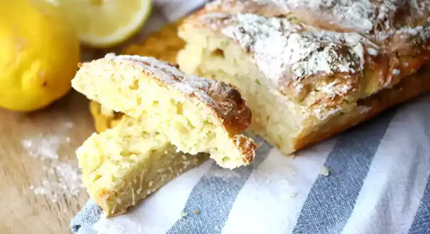 Pain de mie levure chimique, doré et saupoudré de farine, avec des citrons frais à côté.
