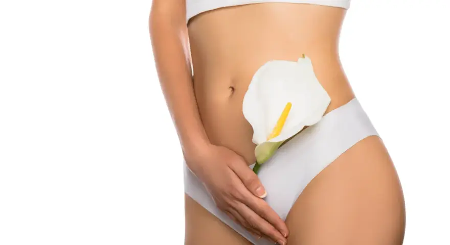 Kobieta w białej bieliźnie trzyma białą kalę. Efekt labioplastyki laserowej przed i po.